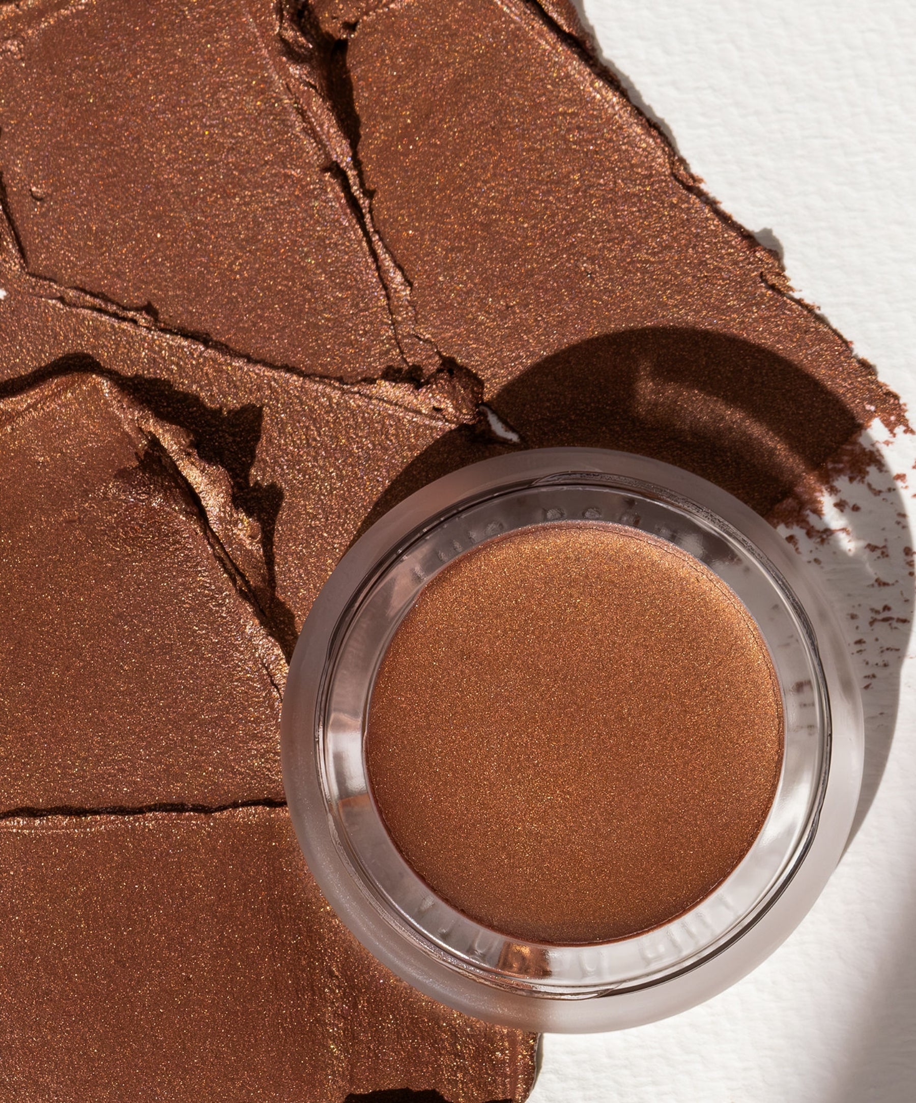 Close-up of Buriti Bronzer, and a swatch of Buriti Bronzer showing the creamy texture.